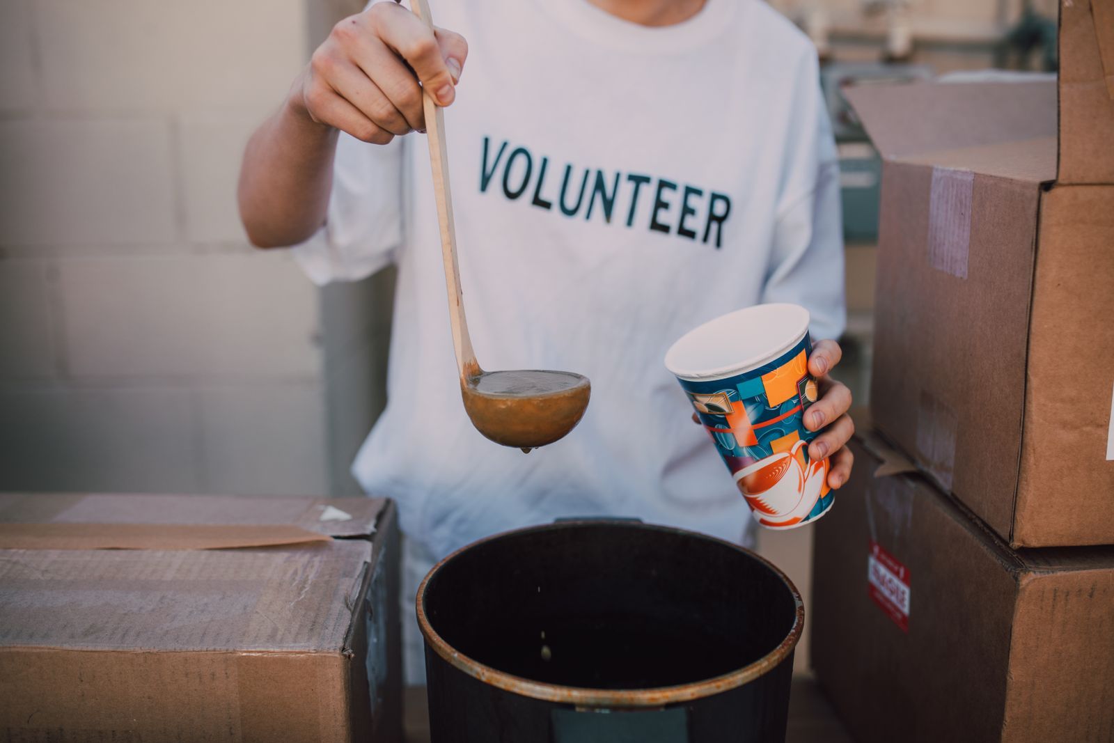 A volunteer ladling soup